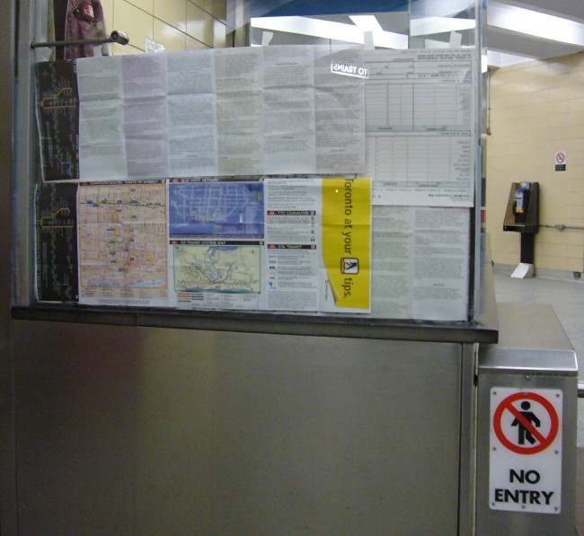 Bottom half of glass of collector booth covered with tacked-up TTC map