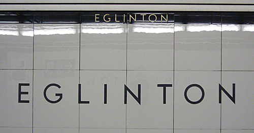 Lightweight black letters on very large glossy grey tiles read EGLINTON