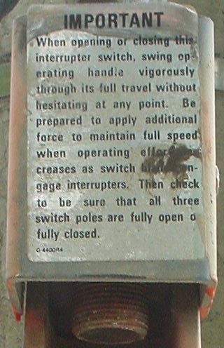 Closeup of warning label on giant throw switch on hydro pole
