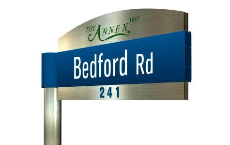 Blue sign blade with Bedford Rd in white, backed by stainless-steel border with The Annex logotype in script