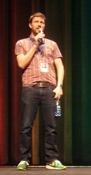 Andrew Haigh onstage, in untucked shirt and green sneakers