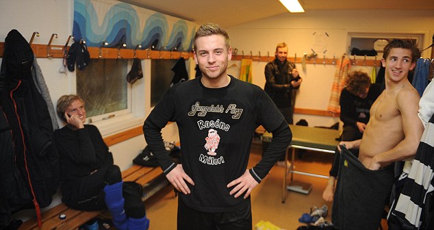 Hysén grins at camera while teammates stand around in dressing room