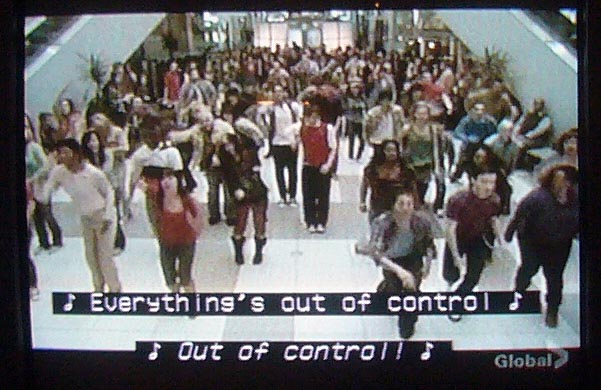 Mass of dancers in mall food court. Caption: ♪ Everything’s out of control ♪