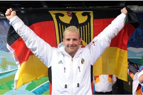 Bleach-blond Lange holding German flag behind him like a cape