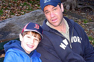 Chris Nutile in baseball cap and zip-up hoodie alongside nephew