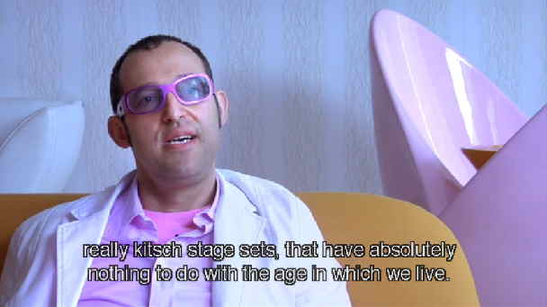 Karim Rashid in pink, pastel, and white clothing and room: really kitsch stage sets that have absolutely nothing to do with the age in which we live