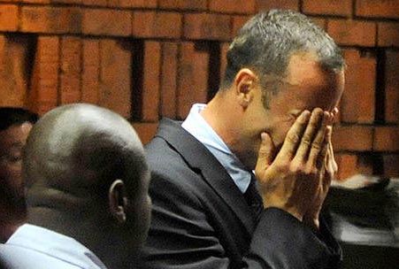 Pistorius stands in court, holding his face in his hands