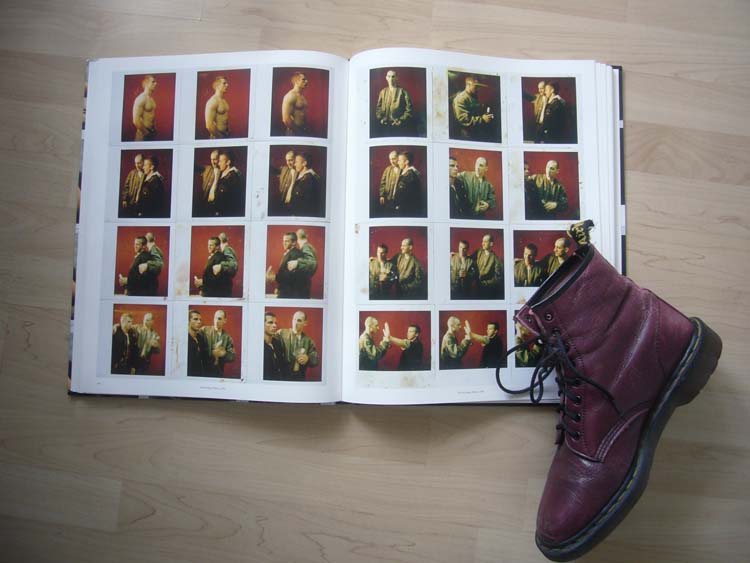 Cherry Doc Marten sits propped on corner of double-page spread of Polaroid photos of skinhead dudes