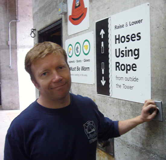 Red-haired fella in blue Toronto Fire T-shirt leans on a concrete wall