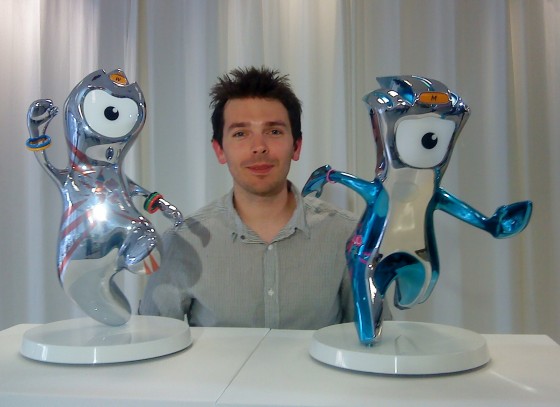 Man poses behind foot-high Wenlock and Mandeville trophies