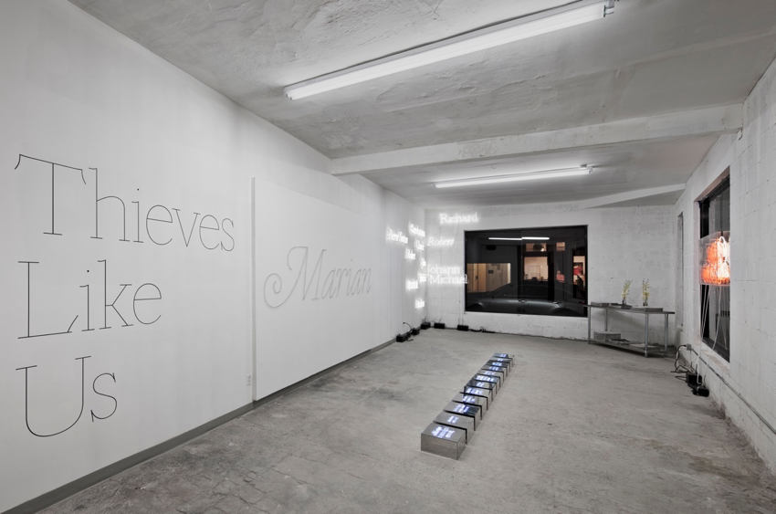 Gallery showing Thieves Like Us and Marian in giant monoline type on white walls