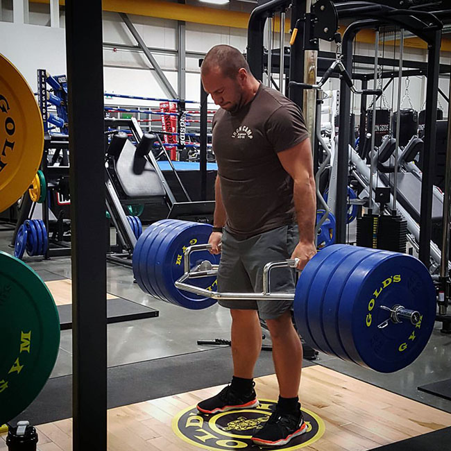 Muscular man hoisting weights in gym