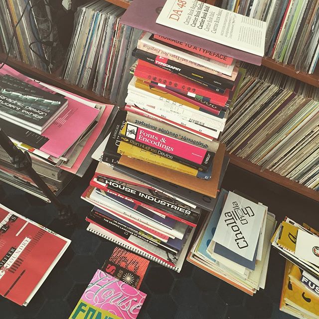 Piles of printed matter in front of LP-record shelves