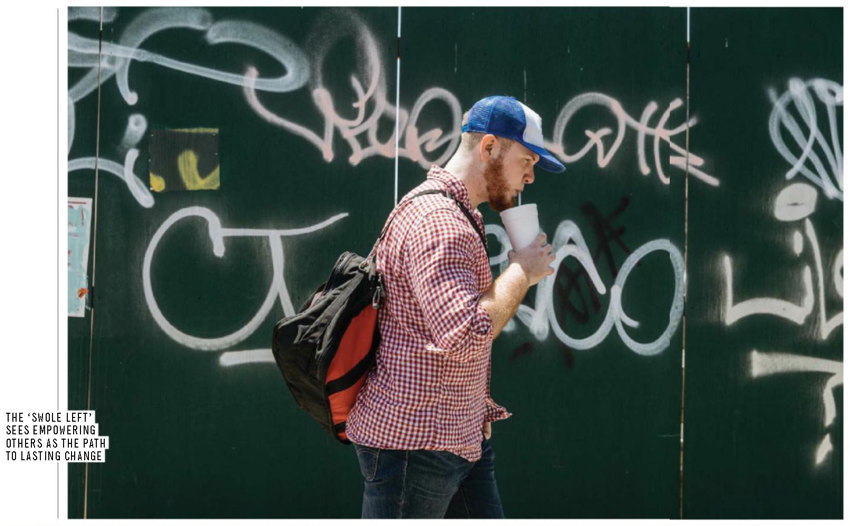 Tubby ginger sips a drink while walking past a graffitied wall