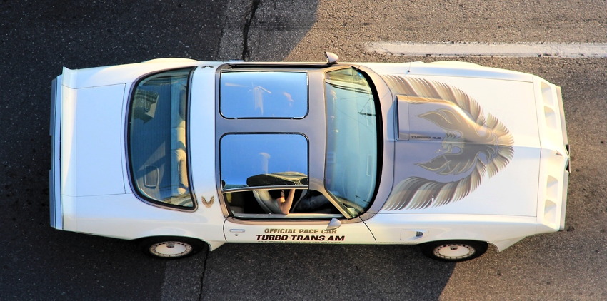 From overhead, a Trans Am with T‑bar glass roof and screaming-eagle decal on hood